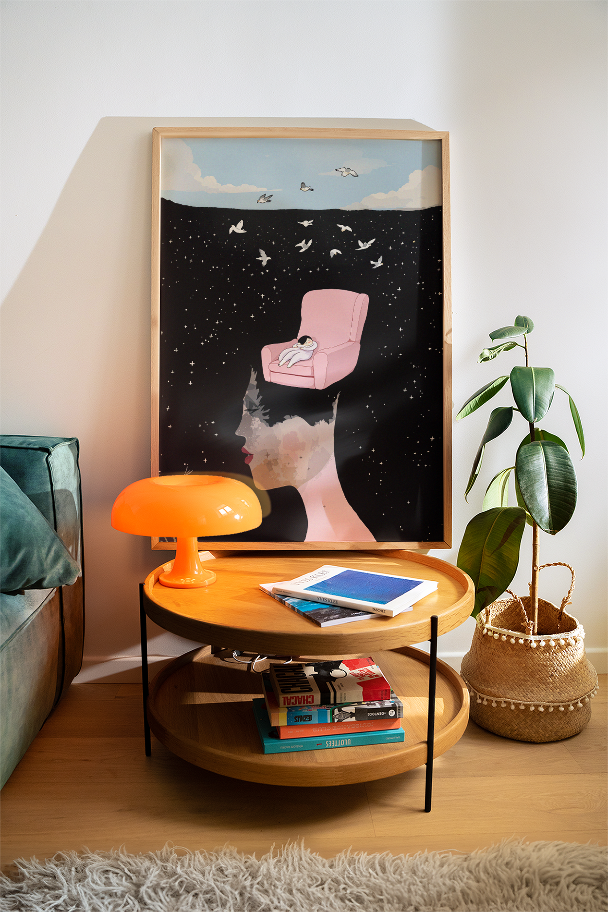 Framed art print in a cool interior setting with an orange lamp, house plant, modern furnishings.