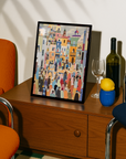 Framed artwork on a wooden side table with a bottle, glass, and lemon.