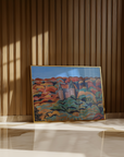 Framed painting of a landscape with a castle on a wooden wall.