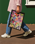 Person holding a colorful framed modern Guernica Picasso poster against a green wall.