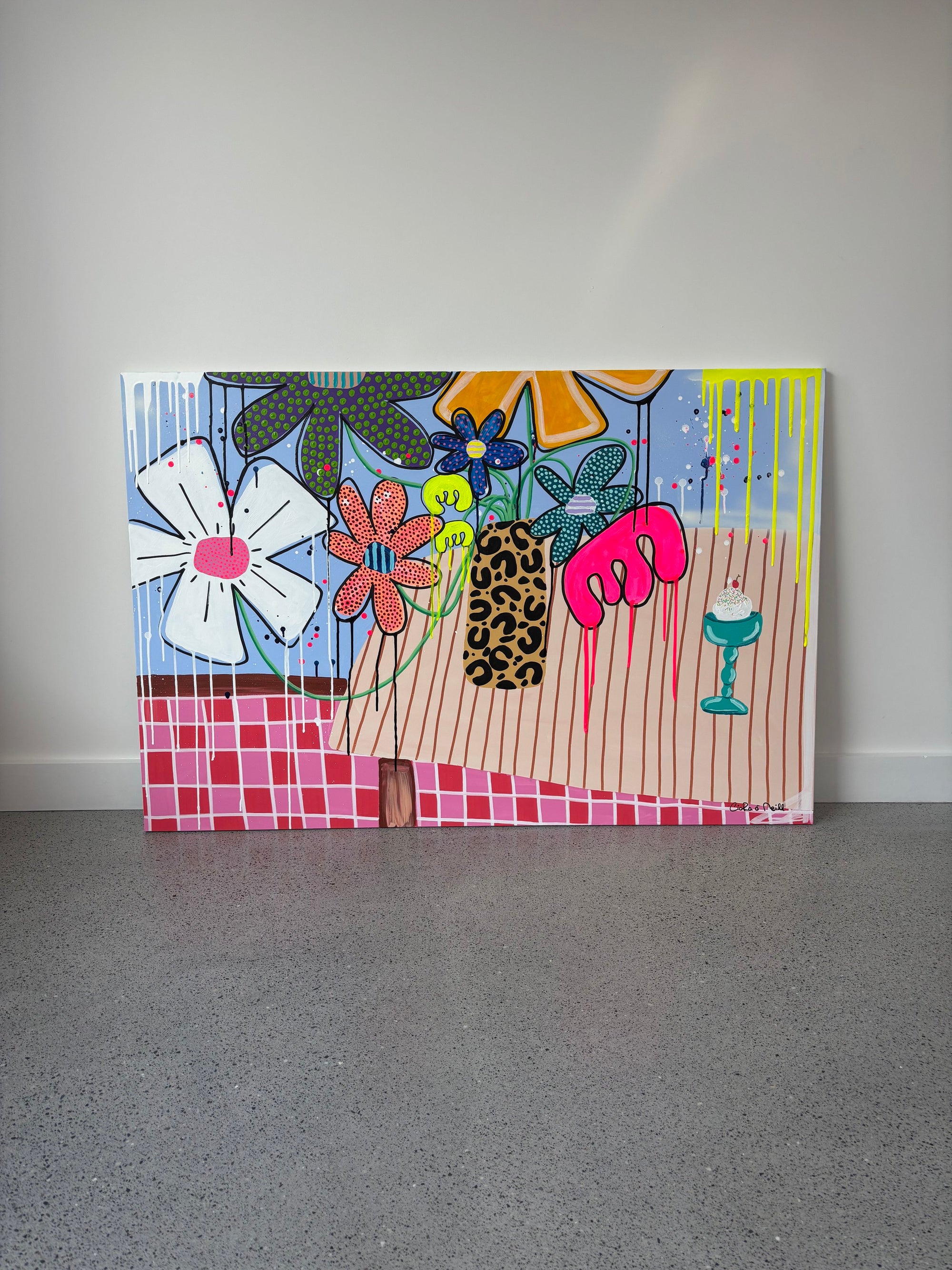 Colorful abstract painting on a gray floor against a white wall