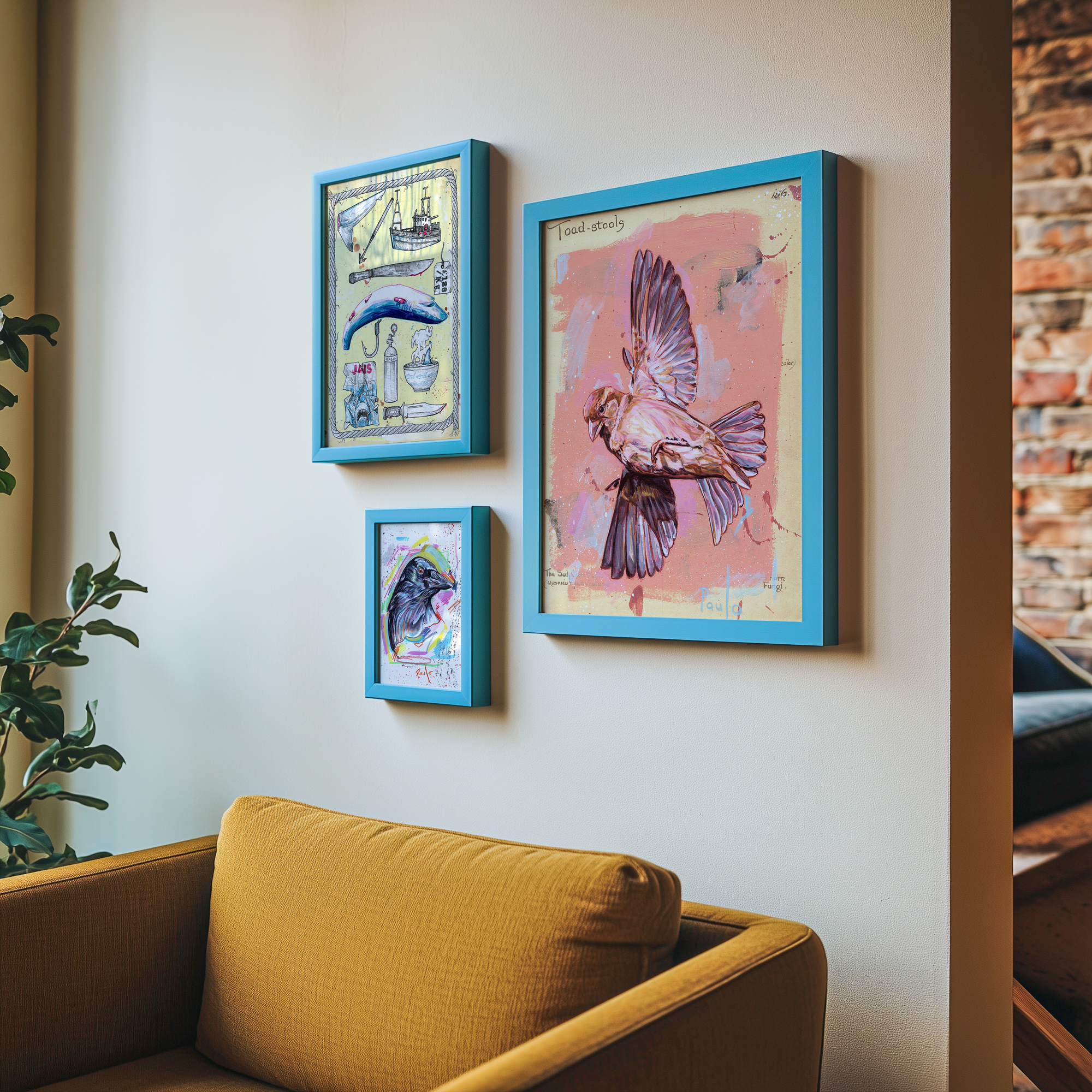 Three framed artworks on a wall above a yellow sofa with a plant to the left.