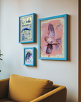 Three framed artworks on a wall above a yellow sofa with a plant to the left.