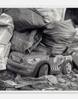 Framed art print of a toy car with taxi design on a pile of newspapers and bags