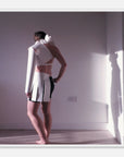 Photo art print of a person wearing a white outfit with black accents in a minimal room.