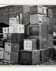 Framed black and white photo of a stack of old electronic equipment against a brick wall