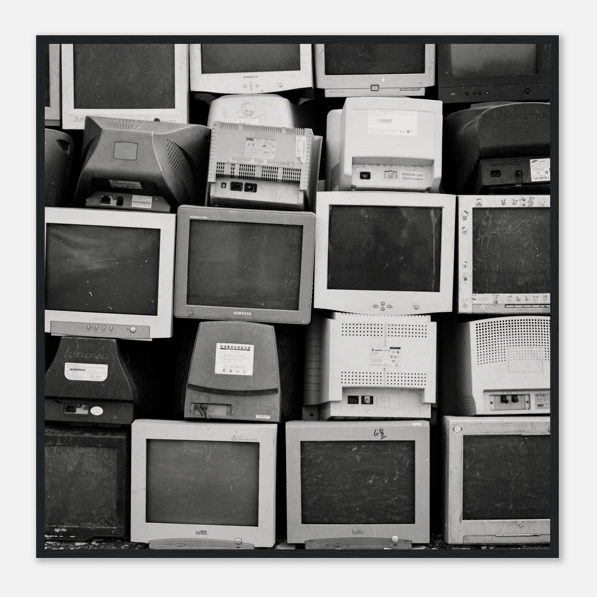 Art print photograph in a black frame depicting a stack of vintage computer monitors in black and white