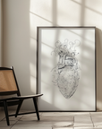 Framed black and white artwork on a wall with a chair and light fixture in the foreground.