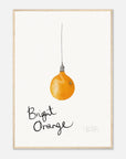 Framed artwork of a bright orange light bulb with 'Bright Orange' text on a white background in a wood frame