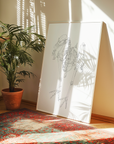 Room interior with a plant, rug, and large white art print with a skeleton diagram.