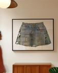 Framed denim skirt on a wall with a person walking by