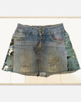 Art print of a denim skirt with embroidery inside a wood frame on a white background