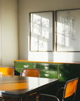 Retro dining room with green sideboard and orange chairs, framed artwork on the wall.