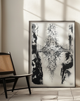 Framed black and white abstract artwork on a wall with a chair and light fixture in the foreground.