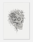 Framed artwork of a skull with flowers and plants growing out of it on a white wall.