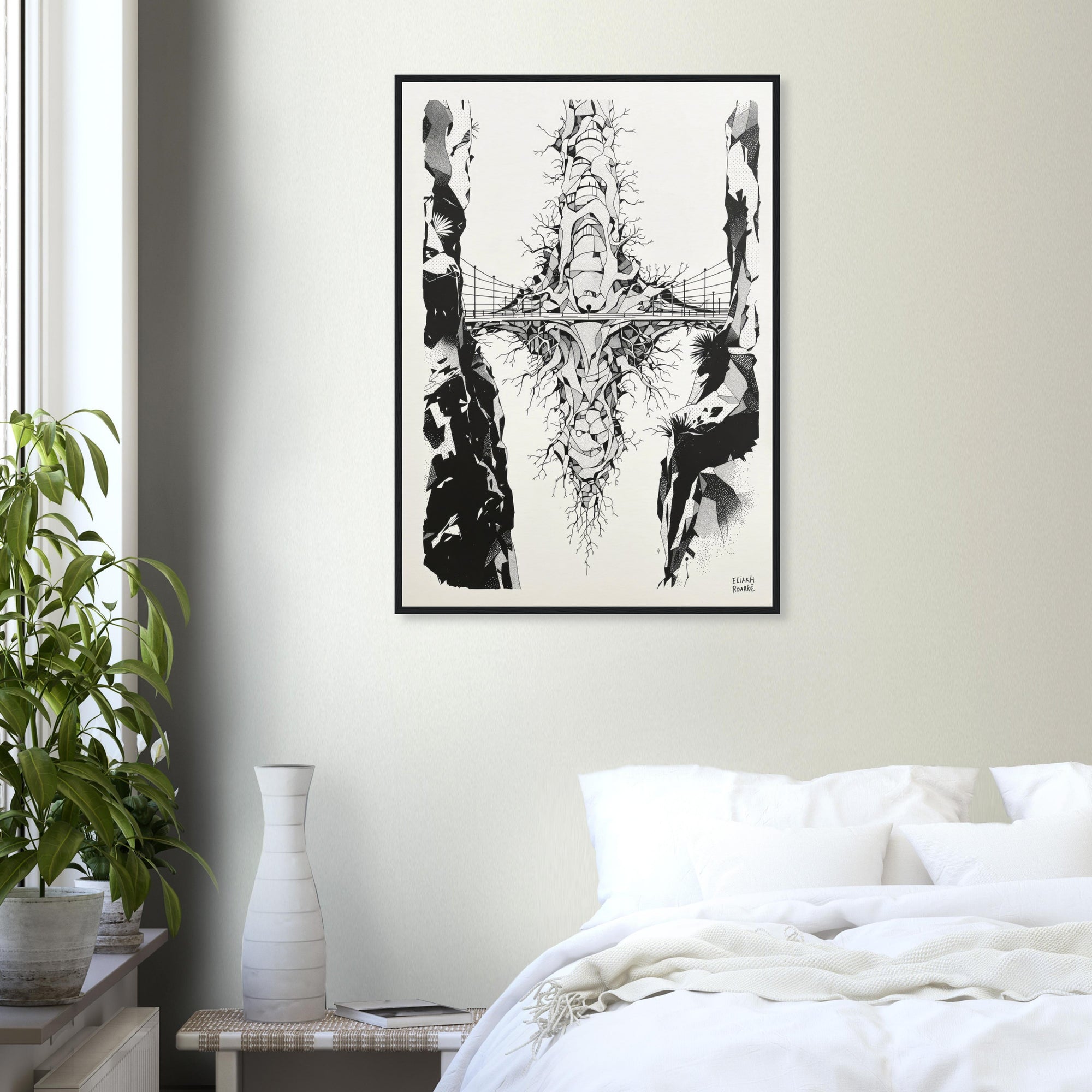 Framed black and white abstract artwork on a wall above a bed in a bedroom.