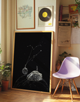 Room interior with a framed black and white constellation drawing, a purple chair, and various decor items.
