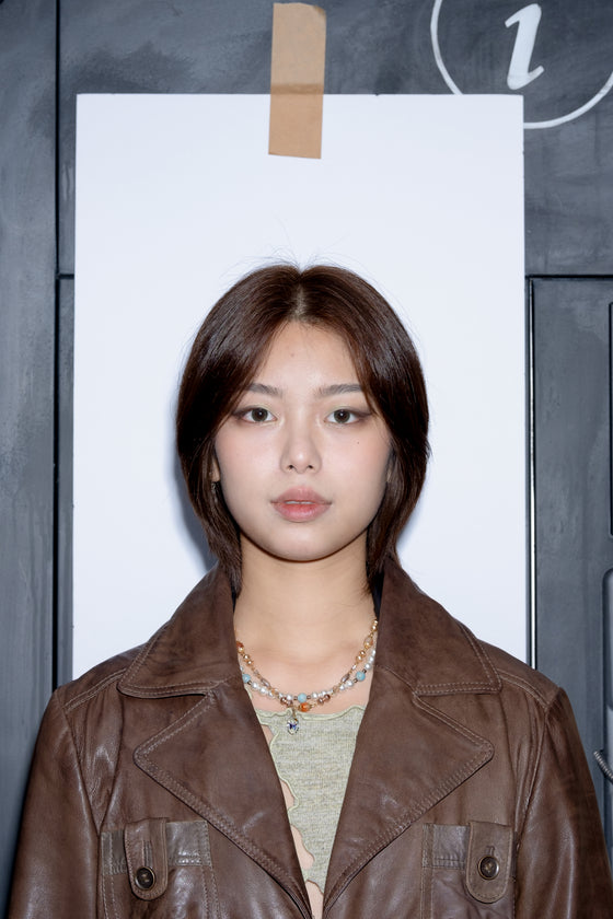Artist called Jenny Ping Lam Lin wearing a brown jacket with a plain background