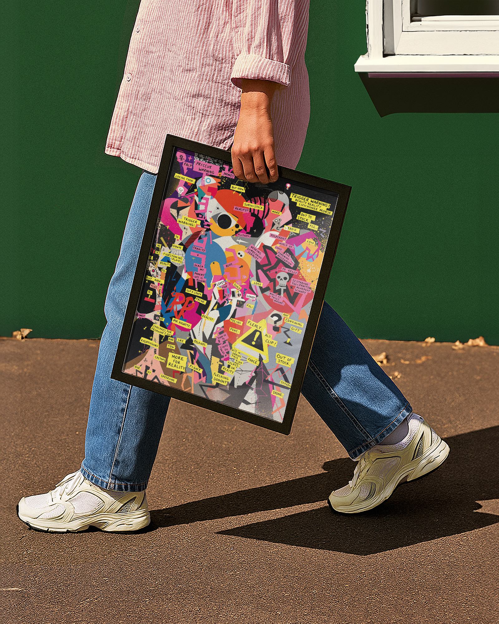 Person holding a colorful framed modern Guernica Picasso poster against a green wall.