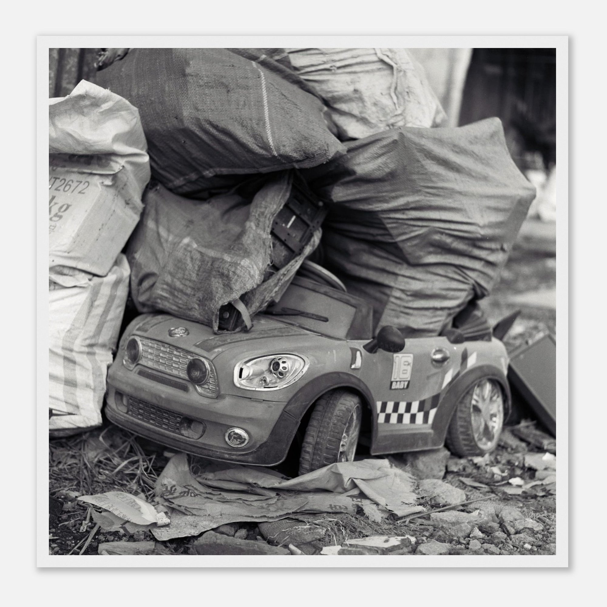 Framed art print of a toy car with taxi design on a pile of newspapers and bags