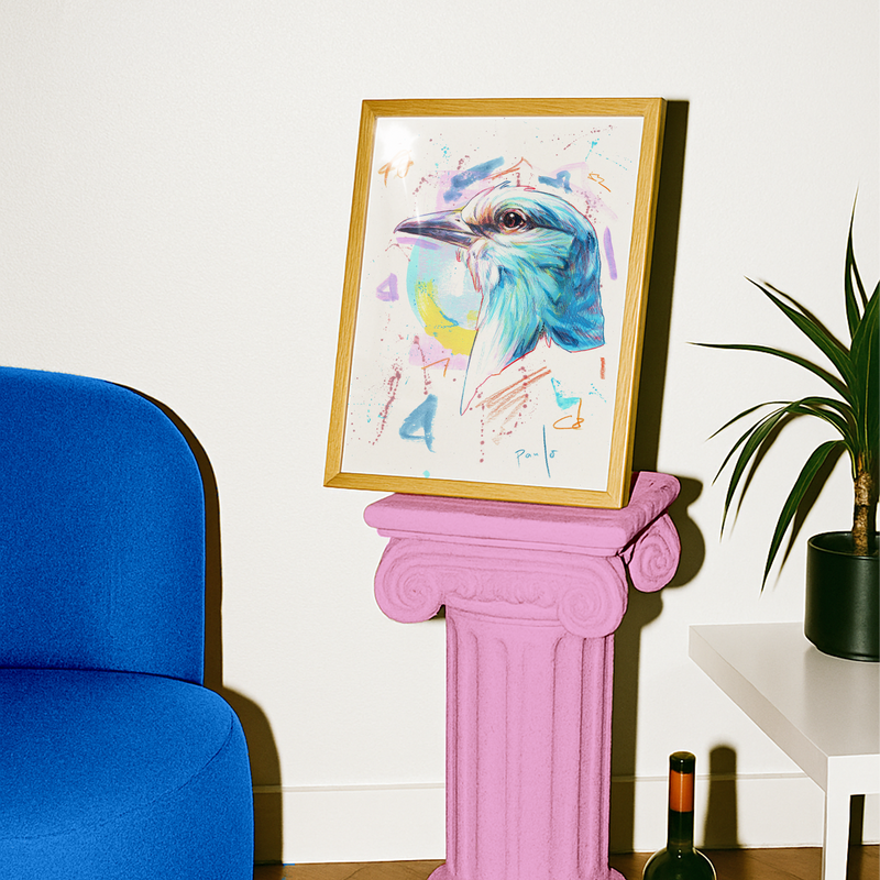 Framed artwork of a colorful bird on a pink pedestal next to a blue chair and plant.