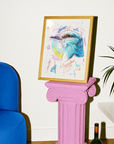 Framed artwork of a colorful bird on a pink pedestal next to a blue chair and plant.
