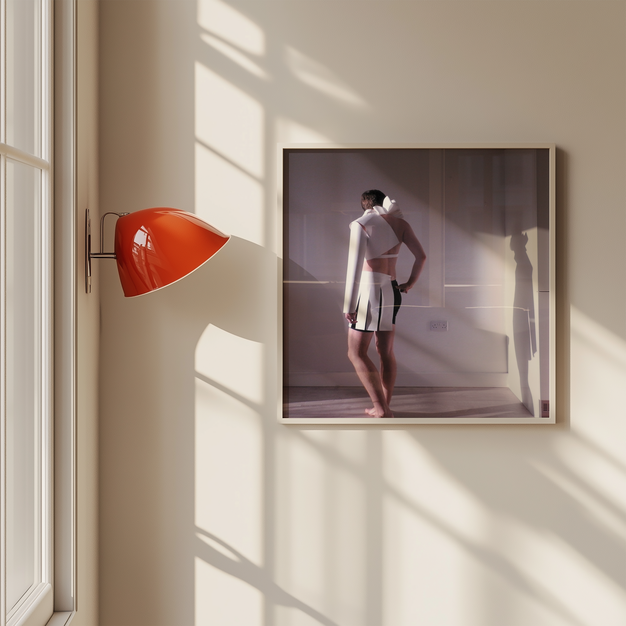 Framed photograph of a person standing in a bathroom on a wall with a red lamp.