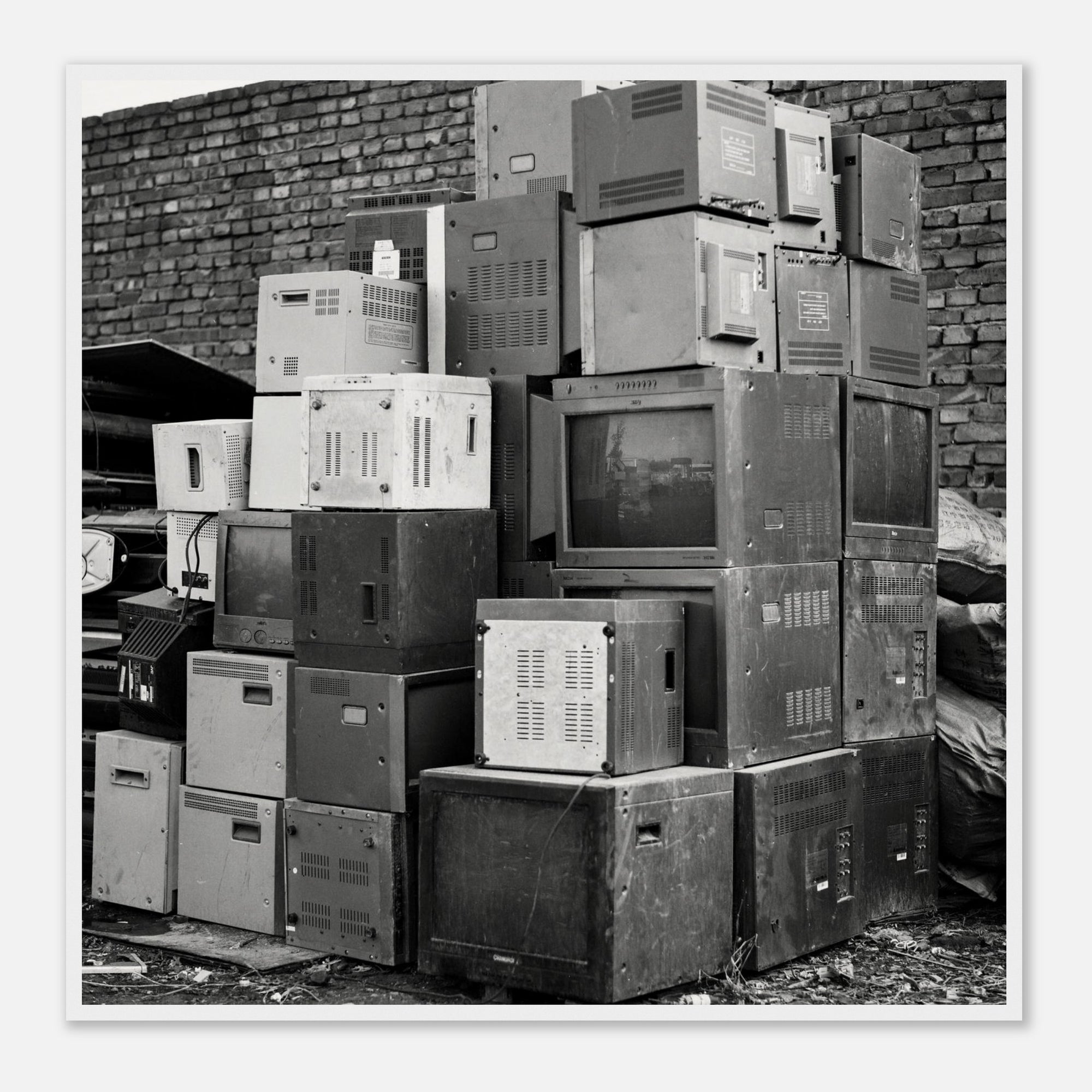 Ready to hang wall art of a stack of old electronic equipment against a brick wall in a white frame