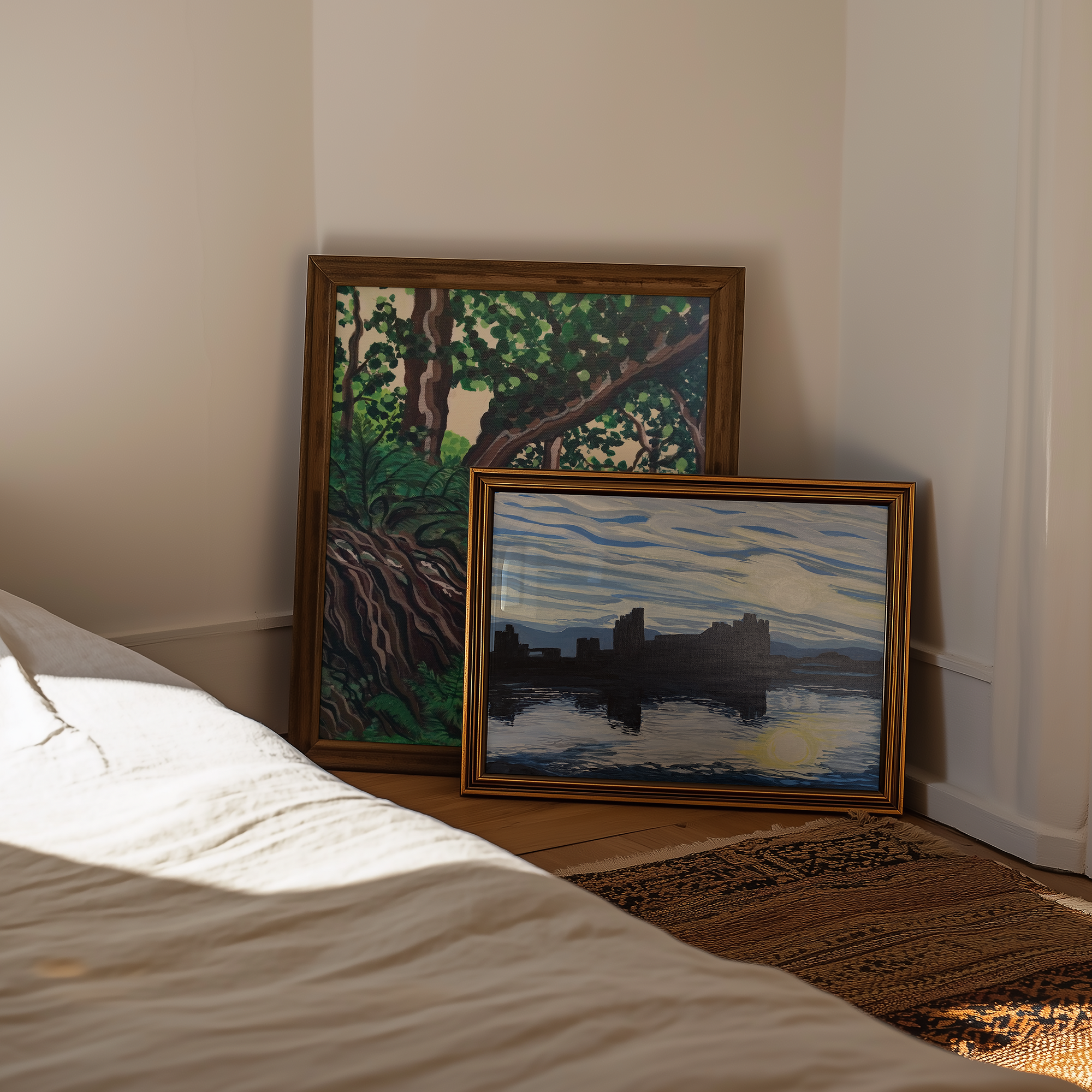 Two framed artworks on a wall next to a bed